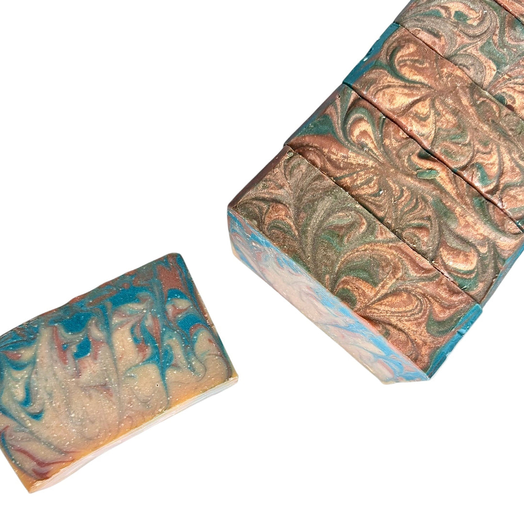 Bad Habit handmade soap bars with copper and teal marbling and subtle shimmer; one single bar and a sliced loaf shown at an angle