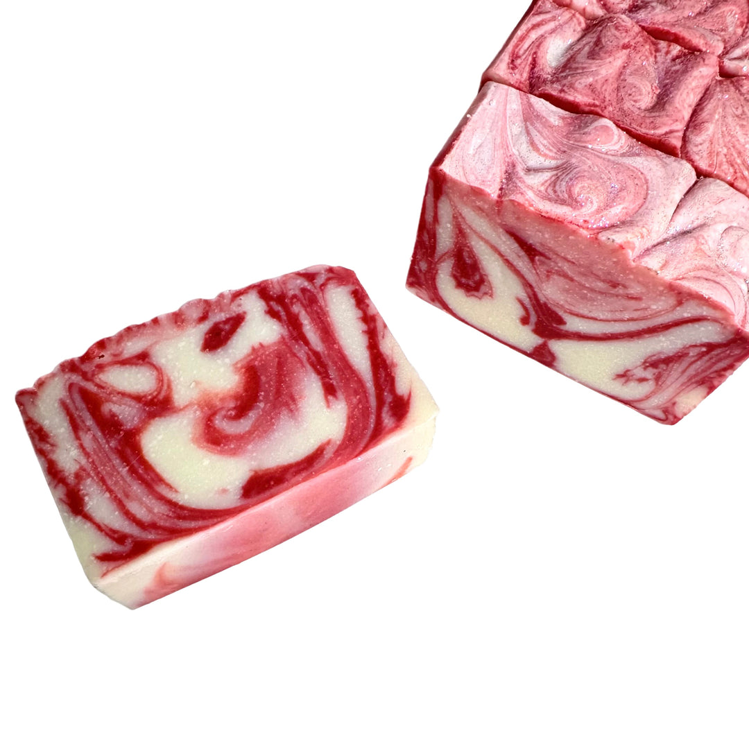 Handcrafted artisan soap bar with bold red and white candy cane swirls, scented with peppermint, Frostbite holiday soap by Dirty Little Suds.