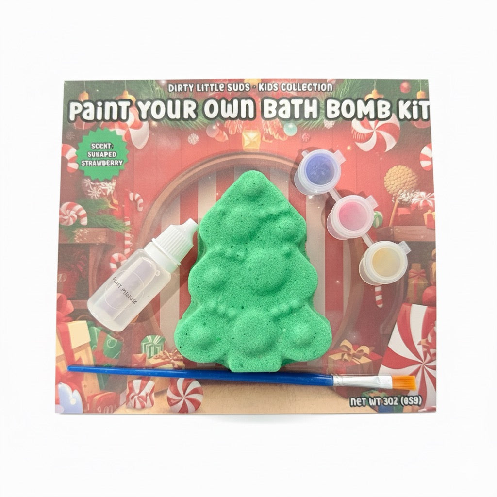 Christmas Paint Your Own Bath Bomb Kit with green tree-shaped bath bomb, paint pots, brush, and activator bottle on a festive holiday backing card | Dirty Little Suds