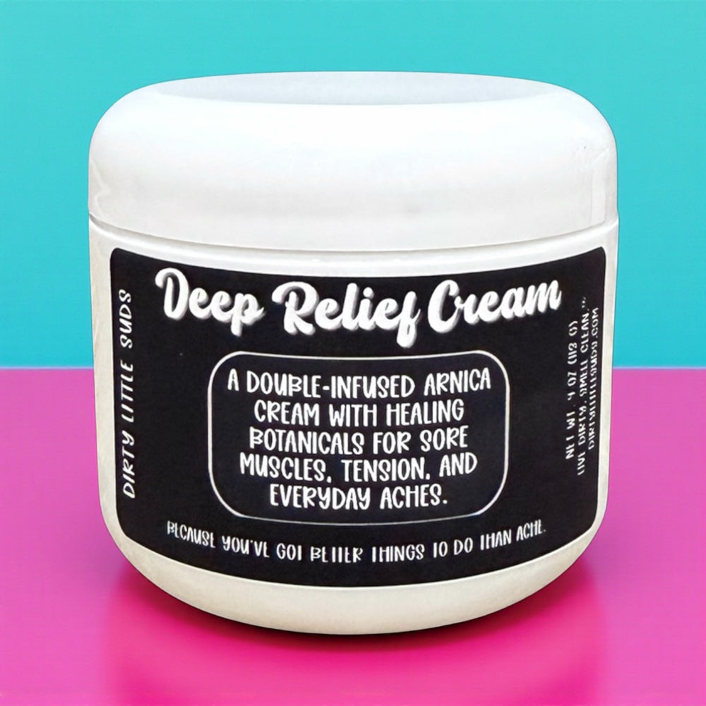 Dirty Little Suds Deep Relief Cream on bold pink and teal background – double-infused arnica and healing botanicals cream for sore muscles, tension, and everyday aches.