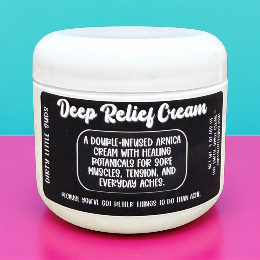 Dirty Little Suds Deep Relief Cream on bold pink and teal background – double-infused arnica and healing botanicals cream for sore muscles, tension, and everyday aches.