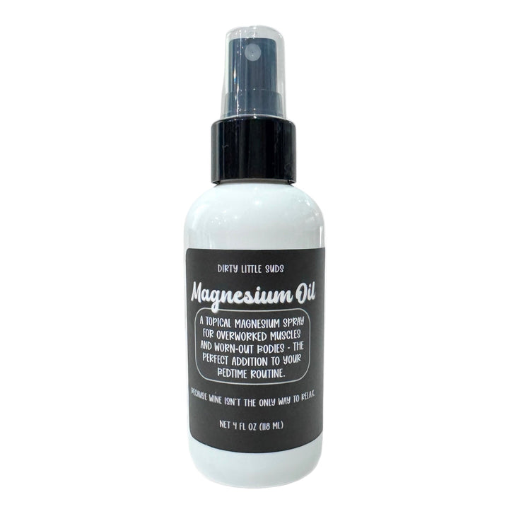 White 4oz bottle of Dirty Little Suds Magnesium Oil spray with black label and spray top. A topical magnesium spray designed for overworked muscles and bedtime relaxation, photographed against a bold colorful background.
