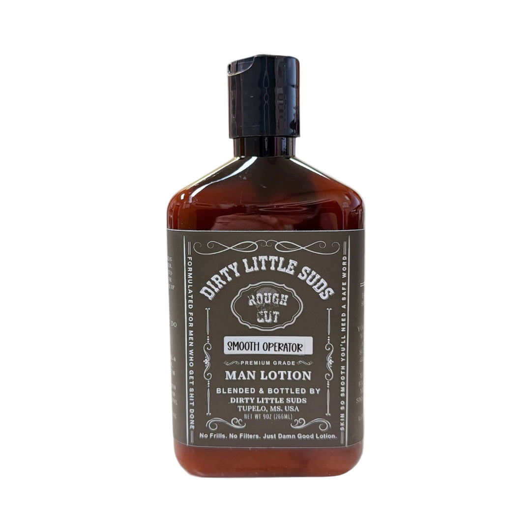 Dirty Little Suds Rough Cut Men’s Lotion in Smooth Operator scent, amber bottle with matte black label. Deep, musky, and clean men’s lotion with dark ocean and warm flannel notes.