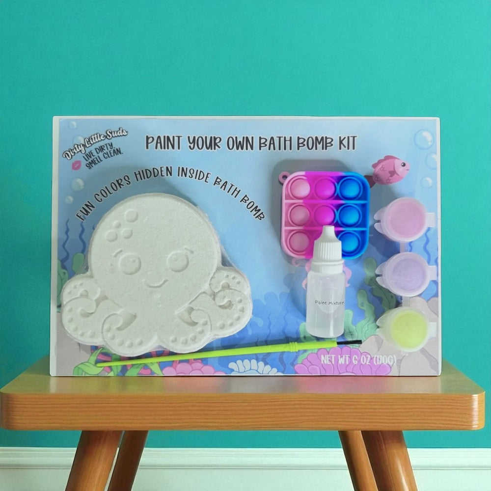 Dirty Little Suds Paint Your Own Bath Bomb Kit – octopus bath bomb with hidden colors, paint set, pop-it toy, and brush displayed against teal background.