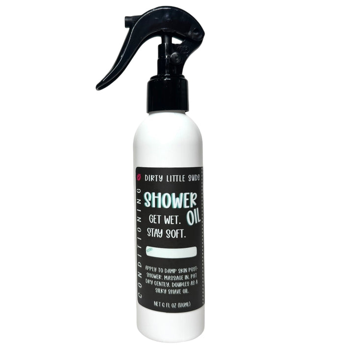 Dirty Little Suds Shower Oil in an 8oz spray bottle with black label, displayed on a plain white background. Lightweight, conditioning shower oil that locks in moisture and leaves skin soft, smooth, and nourished.