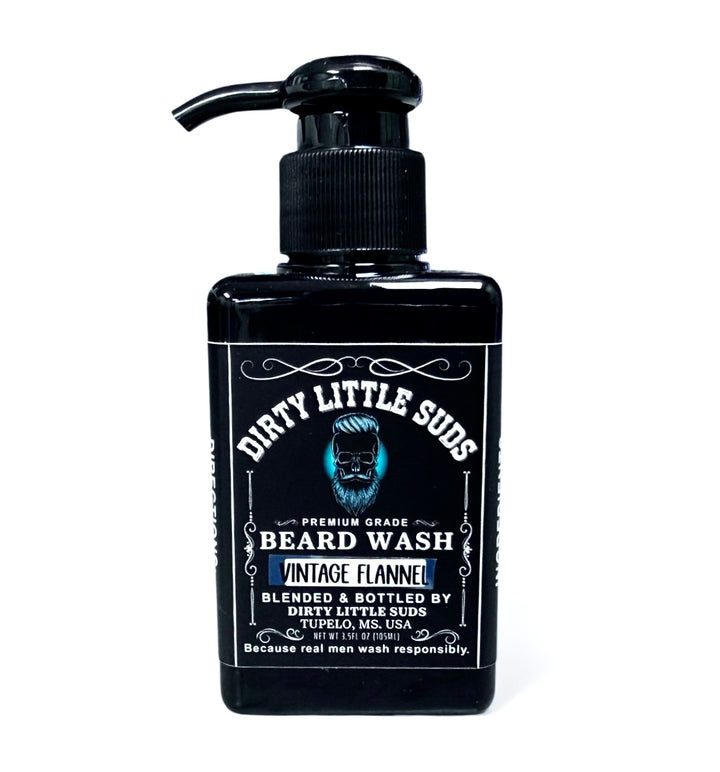 Dirty Little Suds Vintage Flannel Beard Wash shown in a matte black pump bottle with bold white lettering and blue accent label. Sulfate-free beard wash that’s warm, rugged, and refreshing.