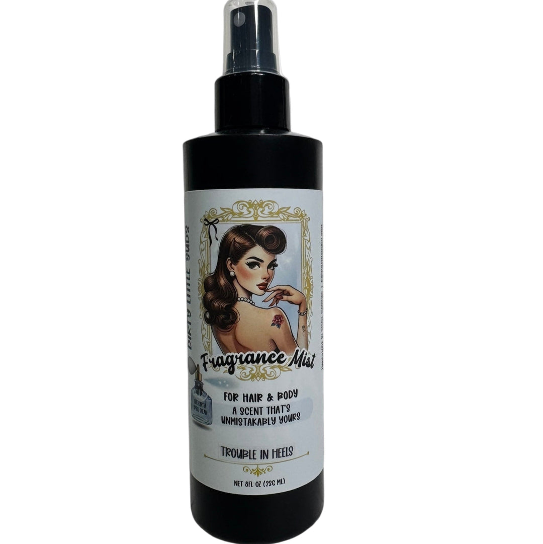 Close-up of a Dirty Little Suds fragrance mist bottle featuring a retro pin-up label design. A long-lasting body spray from the Dirty Little Suds signature scent collection.
