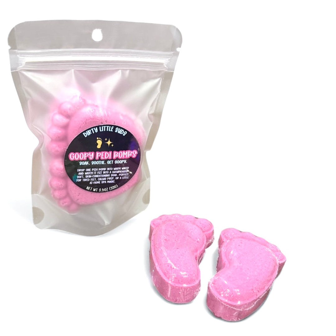 Packaged set of pink Goopy Pedi Bombs® in a clear resealable pouch with label, plus two bombs displayed in front for foot care and pedicure soaking.