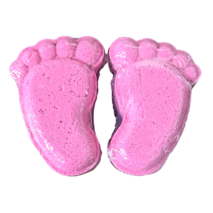 Two bright pink foot-shaped Goopy Pedi Bombs® bath fizzies from Dirty Little Suds, ready for a spa-worthy pedicure soak.