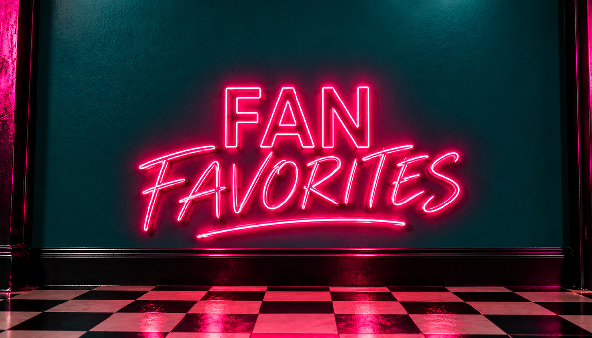 A glowing pink neon sign that reads “FAN FAVORITES” mounted on a dark teal wall above a black-and-white checkered floor.